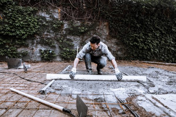 a-worker-scatters-the-cement-with-a-shovel-2025-01-08-23-32-47-utc