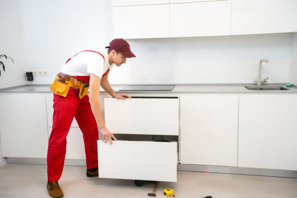 Young man assembling kitchen furniture